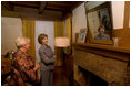 Mrs. Laura Bush looks at a portrait of Laura Ingalls Wilder and her husband on the Wilder home mantle Oct. 3., 2008, in Mansfield, Mo. Laura Ingalls married Almanzo Wilder in the summer of 1885 and moved to the Mansfield home where the "Little House" book series was written in 1894. Mrs. Jean Cody, Director and President of the Laura Ingalls Wilder Historic Home and Museum, explains that the mantle was something that the author really wanted to have. Her husband objected but obviously finally gave in. Wilder, who has been read by children and adults for over 70 years, is one of Mrs. Bush's favorite authors. The visit was used to help encourage American's to read their classic literature which defines us as a nation, reflects our history and bring us together by expressing our shared ideals.