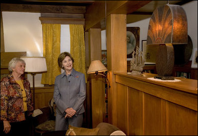 Mrs. Laura Bush admires a steel lamp at the Mansfield, Mo., home of Laura Ingalls Wilder. Mrs. Jean Coday, Director and President of the Laura Ingalls Wilder Historic Home and Museum, explains that the lamp originally belonged to the well-known author's sister. This week the Laura Ingalls Wilder Historic Home and Museum was designated a Save America's Treasures project.