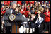 President George W. Bush kisses Army Lieutenant Melissa Stockwell, Paralympian and Iraq war veteran, after she presents President Bush and Mrs. Laura Bush with the American Flag that flew over the Olympic Village in Beijing following his remarks to members of the 2008 United States Summer Olympic and Paralympic Teams Tuesday, Oct. 7, 2008, on the South Lawn of the White House.