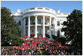 President George W. Bush joined by Mrs. Laura Bush receives applause during his remarks to the members of the 2008 United States Summer Olympic and Paralympic Teams Tuesday, Oct. 7, 2008, on the South Lawn of the White House. President Bush said, "You amazed the world with your talent and grace and sportsmanship. You inspired children to chase their dreams. You will be champions forever."