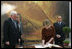 Mrs. Laura Bush signs the guest book Oct. 13, 2008 at the National Gallery of Art in Washington as Italian Prime Minister Silvio Berlusconi waits to sign as well. At left is Mr. Rusty Powell, Director of the National Gallery of Art, who led the tour. The Mt. Vesuvius mural is one of the backdrops for the exhibit.