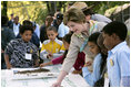 Mrs. Laura Bush and children from the Adam Clayton Powell Jr. Elementary School (P.S. 153) and the Boys and Girls Club of Harlem do a 'soil sampling' as part of the First Bloom program at the Hamilton Grange National Memorial in New York City, Sept. 24, 2008. The activity helps children learn about the characteristics of local soil and thus the kinds of plants best suited to the area. The park is the historic home of Alexander Hamilton. 