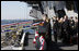 President George W. Bush stands with Mrs. Laura Bush during the playing of the national anthem at the commissioning ceremony of the USS George H. W. Bush (CVN 77) aircraft carrier Saturday, Jan 10, 2009 in Norfolk, Va., in honor of his father, former President George H. W. Bush, seen at right.