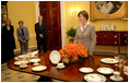 Mrs. Laura Bush meets reporters as she announces two new White House china patterns, Wednesday, Jan. 7, 2009 in the Family Dining Room of the State Floor of the White House for their unveiling of the George W. Bush State China and the Magnolia Residence China. The George W. Bush State China was inspired from a Madison-era dinner service. The Magnolia Residence China is in the picture foreground and the George W. Bush State China is on the left side of the table. With Mrs. Bush from left are Amy Zantsinger, White House Social Secretary, Nancy Clarke, White House Florist, and Bill Allman, White House Curator.