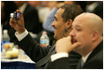 Homeboy Industries representatives, Gabriel Hinojos takes a photo of his mentor, Father Gregory Boyle, as the founder of Homeboy Industries/Jobs for a Future, spoke on stage, Thursday, Oct. 27, 2005 at Howard University in Washington, at the White House Conference on Helping America's Youth. Gustavo Mojica, also of Homeboy Industries, is seen foreground. 