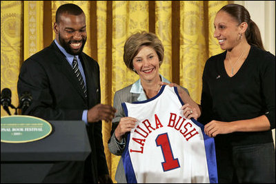 Golden State Warrior Baron Davis, left, and Phoenix Mercury guard Diana Taurasi, right, present Laura Bush with a basketball jersey at the National Book Festival Author's breakfast in the East Room Saturday, Sept. 24, 2005.