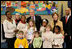 President George W. Bush and Laura Bush are joined by Washington, D.C. Mayor Adrian Fenty, right, and Ginnie Cooper,Chief Librarian for the Washington, D.C. libraries, left, posing for photos with children and staff at a reading class commemorating Martin Luther King Day Monday, Jan. 21, 2008, at the Martin Luther King Jr. Memorial Library.