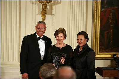 Mrs. Laura Bush is joined on stage by former Secretary of State Colin Powell and his wife, Alma Powell, as they present Mrs. Bush with a National Promise of America Founders Award, Tuesday evening, Nov. 13, 2007, during a social dinner to celebrate the tenth anniversary of America's Promise-The Alliance for Youth.