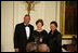 Mrs. Laura Bush is joined on stage by former Secretary of State Colin Powell and his wife, Alma Powell, as they present Mrs. Bush with a National Promise of America Founders Award, Tuesday evening, Nov. 13, 2007, during a social dinner to celebrate the tenth anniversary of America's Promise-The Alliance for Youth.