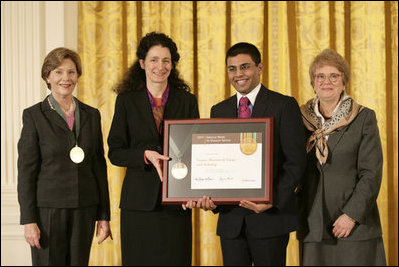 Mrs. Laura Bush along with Dr. Anne Radice, the Director of the Institute of Museum and Library Services, right, presents a 2007 National Awards for Museum and Library Services awards to both Nancy Stueber, Director, and Priyam Shah, Community Representative of the Oregon Museum of Science & Industry, Portland, OR, during a ceremony in the East Room at the White House Monday, January 14, 2008. "Regular visitors to OMSI can touch a tornado, uncover a fossil, experience an earthquake, visit the Northwest's largest planetarium, explore a Navy submarine, or just experiment on their own in one of eight hands-on labs." Mrs. Bush said of the Oregon Museum of Science & Industry during her remarks.