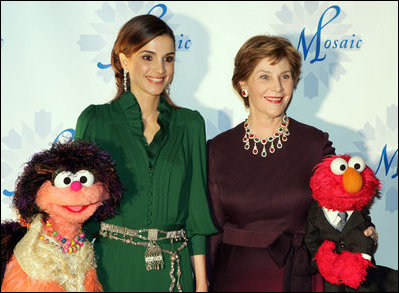 Mrs. Laura Bush stands with Her Majesty Queen Rania Al-Abdullah of Jordan and Sesame Street characters Khokha, left, and Elmo during a dinner celebrating the partnership between the Sesame Workshop and the Mosaic Foundation at the National Building Museum in Washington, D.C., Wednesday, May 9, 2006. Founded by the spouses of Arab Ambassadors to the United States, the Mosaic Foundation is dedicated to improving the lives of women and children. White House photo by Shealah Craighead 