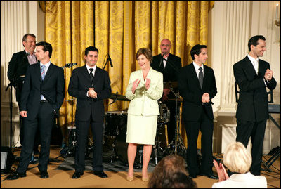 Mrs. Laura Bush stands with members of the cast from the Tony award-winning musical "Jersey Boys" as they perform during a luncheon for Senate Spouses in the East Room, Monday, June 12, 2006. White House photo by Shealah Craighead 