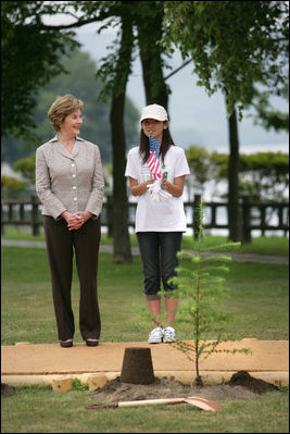 Mrs. Laura Bush stands with Natsumi Kagawa, age 11, after planting a tree at the Toyako New Mount Showa Memorial Park Wednesday, July 8, 2008, during the ceremony in Hokkaido, Japan. The wives of each of the G8 Summit leaders planted a small evergreen tree along a park walkway.