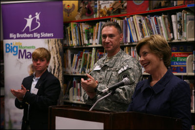 Mrs. Laura Bush is applauded during her address to students, faculty and guests at the Good Shepherd Nativity Mission School, Thursday, Nov. 1, 2007 in New Orleans, during a Helping America's Youth visit with Big Brother and Big Sisters of Southeast Louisiana. Mrs. Bush spoke about the importance of adults as positive role models in young children's lives. Student Taylor McIntyre is seen at left, joined by his Big Brother Captain Richard T. Douget.