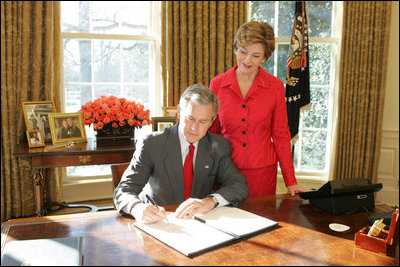 With Laura Bush looking on, President George W. Bush signs a proclamation designating February as American Heart Month in the Oval Office, Feb. 1, 2005. The proclamation encourages awareness of factors leading to heart disease such as smoking, high cholesterol, lack of exercise, obesity and diabetes.