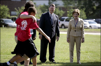 Mrs. Laura Bush and Mike Gottfried, CEO of Team Focus, watch Team Focus participants run a relay race Thursday, June 21, 2007, in Mobile, Ala., during a visit to Team Focus's National Leadership Camp, as part of Helping America’s Youth initiative. Team Focus is a faith-based, nonprofit organization devoted to improving the lives of young men, ages 10-18, without fathers in their lives.