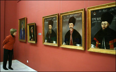 Mrs. Laura Bush peers in for a closer view of artwork during a visit Thursday, April 3, 2008, to the National Art Museum in Bucharest.