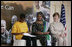 Mrs. Laura Bush and Mrs. Salma Kikwete, First Lady of Tanzania, enjoy Salvation Army Children as they perform on stage Sunday, Feb. 17, 2008, at the WAMA Foundation in Dar es Salaam. The foundation, founded by Mrs. Kikwete, is a non-profit organization focusing on development by improving women’s social and economic status by redefining gender roles and creating more opportunities for the development of women and children.