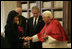 As President George W. Bush looks on, Mrs. Laura Bush shakes the hand of Pope Benedict XVI Saturday, June 9, 2007, during their visit to The Vatican in Rome.