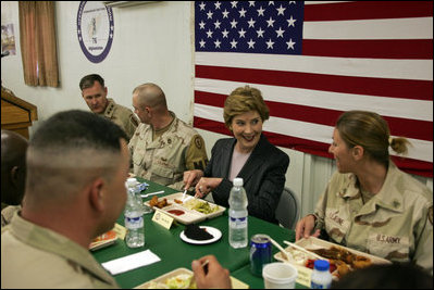 Laura Bush laughs with troops as they eat dinner in the Dragon Chow Dining Hall at Bagram Air Base in Kabul, Afghanistan, Wednesday, March 30, 2005. 