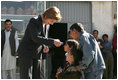 Laura Bush hands red, white and blue kaleidoscopes to youngsters outside a Kabul bakery Wednesday, March 30, 2005 during her visit to Afghanistan. 