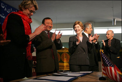 Laura Bush applauds as Secretary of Education Margaret Spellings and Afghan Minister of Education Noor Mohammas Qarqeen complete the signing of the Memorandum of Understanding for funds to build a university in Kabul, Afghanistan, Wednesday, March 30, 2005. 