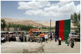 Mrs. Laura Bush, to the right of the podium, is introduced June 8, 2008 by the Governor Habiba Sarabi as workmen prepare to break ground for the Bamiyan Bazaar road project in Afghanistan.