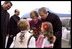 President George W. Bush and Laura Bush are greeted by children at the airport in Bucharest, Romania Saturday, Nov. 23, 2002.