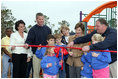 Laura Bush attends a ribbon cutting ceremony with football star Brett Favre and his wife, Deanna, left, Secretary Margaret Spelling, center, Darell Hammond, Associate Director, USA Fredom Corps, right, and student of Hancock North Central Elementary Shool at the Kaboom Playground, built at the Hancock North Central Elementary School in Kiln, Ms., Wednesday, Jan. 26, 2006, during a visit to the area ravaged by Hurricane Katrina.