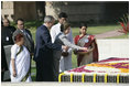 President George W. Bush and Laura Bush sprinkle flowers on the south side of the Mahatma Gandhi Memorial Thursday, March 2, 2006, during a wreath-laying ceremony in Rajghat, India.