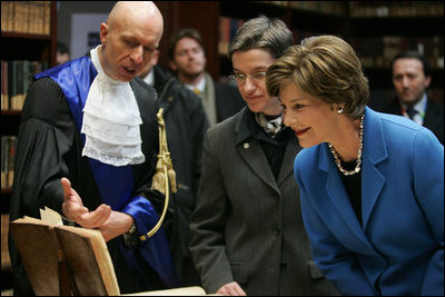 Laura Bush looks at an Ancient Thesis of Montichelli during a tour given by Paolo Novaria, Archives, left, at the University of Turin Saturday, Feb. 11, 2006, in Turin, Italy.