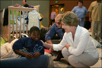 Laura Bush visits with a young boy displaced by Hurricane Katrina in the Cajundome at the University of Louisiana in Lafayette, La., Friday, Sept. 2, 2005.