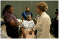 Laura Bush reaches out to a victim of Hurricane Katrina during a visit Friday, Sept. 2, 2005, to the Cajundome at the University of Louisiana in Lafayette.  "The people of this part of the United States, the Lafayette area of Louisiana, are very, very warm people," said Mrs. Bush.  "They've opened their hearts, and many of them have opened their homes, as well, to people from New Orleans -- family members and strangers."