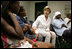 Laura Bush visits with people affected by Hurricane Katrina in the Cajundome at the University of Louisiana in Lafayette, La., Friday, Sept. 2, 2005.