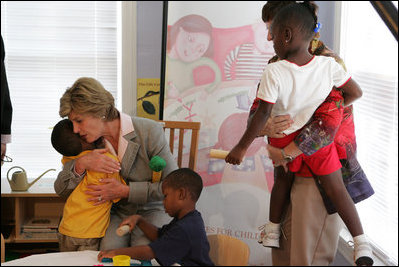 Mrs. Laura Bush receives a hug from a young boy at the House of Tiny Treasures in Houston during her visit Monday, Sept. 19, 2005.  The House enables parents to search for jobs and housing, and to run errands while their children receive good care from credentialed teachers.