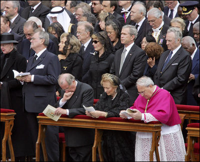 President George W. Bush and Laura Bush stand amidst mourners at funeral services Friday, April 8, 2005, for the late Pope John Paul II in St. Peter's Square.