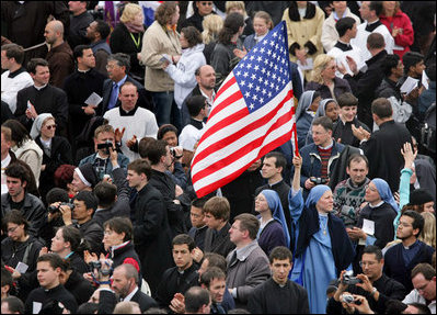 An American flag flies high above the throng of mourners inside St. Peter's Square Friday, April 8, 2005, as thousands attend funeral mass for Pope John Paul II, who died April 2 at the age of 84.