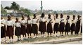 Students at Model Secondary School in Abuja, Nigeria, wave American flags as they line the street during a visit by Laura Bush Wednesday, Jan. 18, 2006.