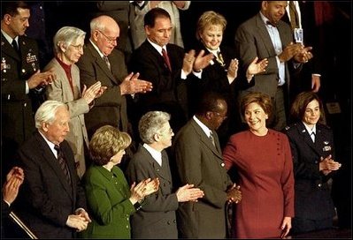 Laura Bush turns to her guest, Dr. Peter Mugyenyi of Uganda, during President George W. Bush's State of the Union address at the U.S. Capitol Tuesday, Jan. 28, 2003. Serving as chairman for several efforts fighting the spread of the AIDS virus, Dr. Mugyenyi directs the Joint Clinical Research Center in Uganda. In his speech President Bush asked Congress to commit $15 billion to afflicted African nations and the Caribbean. White House photo by Susan Sterner