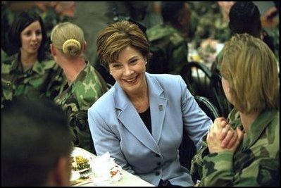 Laura Bush talks with members of the 101st Airborne at Fort Campbell, Kentucky. Known as "The Screaming Eagles," this airborne division took part in the largest airborne assault of World War II and also served in Vietnam. Surrounded by the soldiers, Mrs. Bush shares a turkey dinner with them Wednesday, Nov. 21, 2001. 