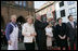 Standing with German Chancellor Angela Merkel, President George W. Bush holds up a ceremonial gift of a barrel of herring in Stralsund, Germany, Thursday, July 13, 2006. Mrs. Bush is pictured at the right.