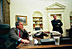 Chief of Staff Andy Card stands by as President George W. Bush talks with World Leaders and members of Congress after the capture of Saddam Hussein in the Oval Office Dec. 14, 2003. 