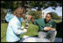 A volunteer helps a youngster with her First Bloom, seed-planting Sunday, Oct. 19, 2008, during the Fall Garden Tour of the White House.