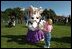 Enjoying the sunny day, a young visitor at the White House Easter Egg Roll meets one of the Easter bunnies on the South Lawn, Monday, April 1, 2002. 