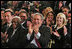 President George W. Bush applauds during the Celebration of Hispanic Heritage Month in the East Room, Thursday, Oct 2, 2003. Also pictured from left are, Tony Garza, U.S. Ambassador to Mexico and Pedro Knight, the husband of late singer Celia Cruz.