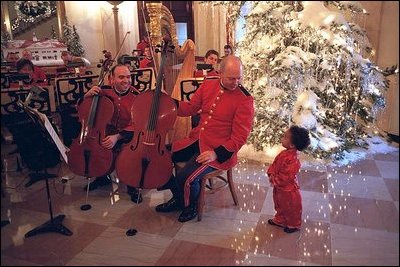 A member of the Marine Band greets a young fan in the Cross Hall during the 2001 holiday season at the White House.