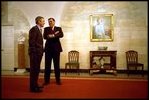 Before taking a photo with Hispanic members of his staff as part of the Cinco de Mayo celebrations, President George W. Bush speaks with Secretary for Housing and Urban Development Mel Martinez in the downstairs corridor May 3, 2002. The corridor was redesigned as the visitor’s entrance to the White House in 1902.