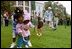 A helping hand is given during the Easter egg roll where little competitors use a spoon to carry a hard-boiled egg through the South Lawn race course and across the finish line at the White House Easter Egg Roll Monday, April 21, 2003. 