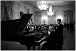 Former President Harry Truman tickles the ivories for President and Mrs. Kennedy in the East Room November 1, 1961.