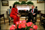 President George W. Bush and Coretta Scott King, the widow of Dr. Martin Luther King, Jr., share a laugh in the Oval Office Jan. 21, 2002. President George W. Bush honored Dr. King in a White House celebration and received a portrait of the civil rights leader from his wife and children in the East Room.